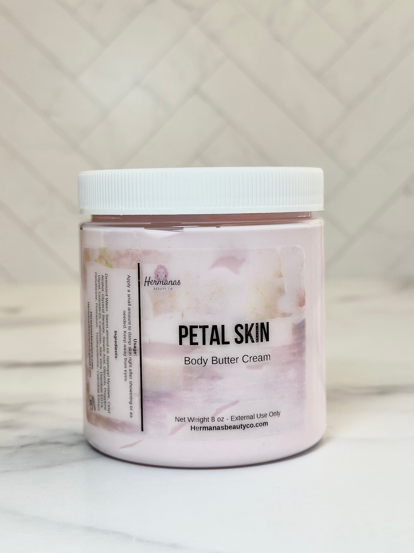 Jar of Petal Skin body butter cream on a marble surface with a neutral background