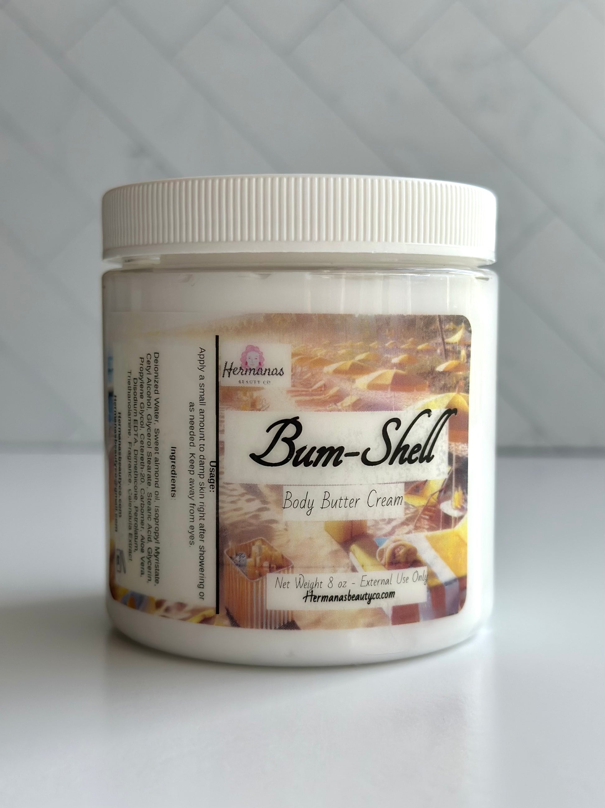 Clear body butter jar with a gold and brown label