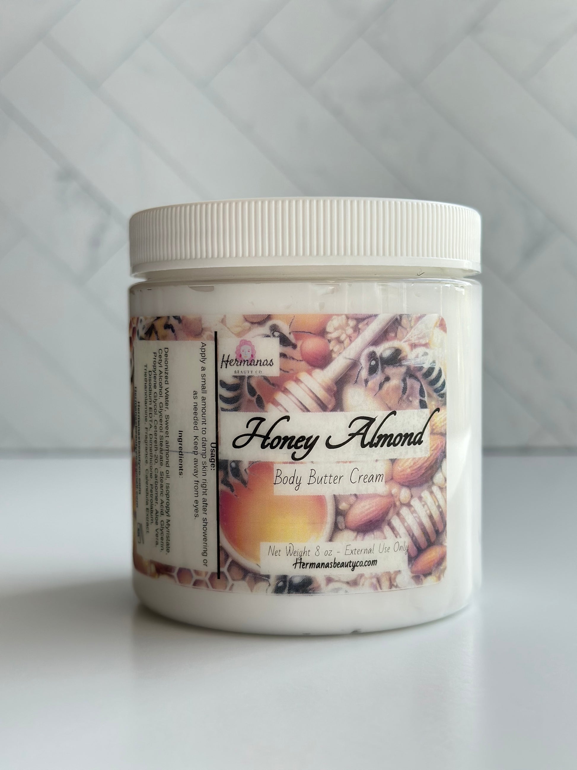 Clear body butter jar with a gold and brown label