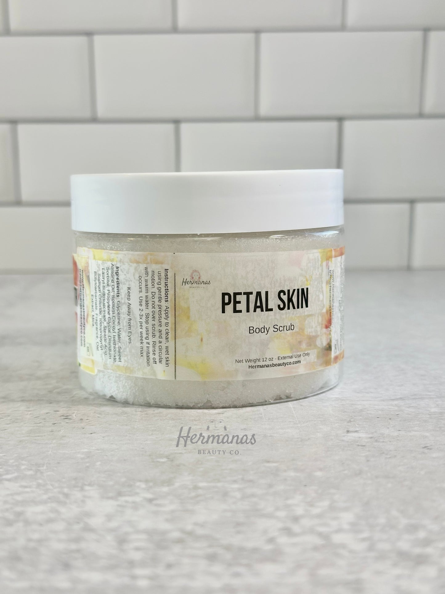 Jar of 'Petal Skin' body scrub on a tiled bathroom wall