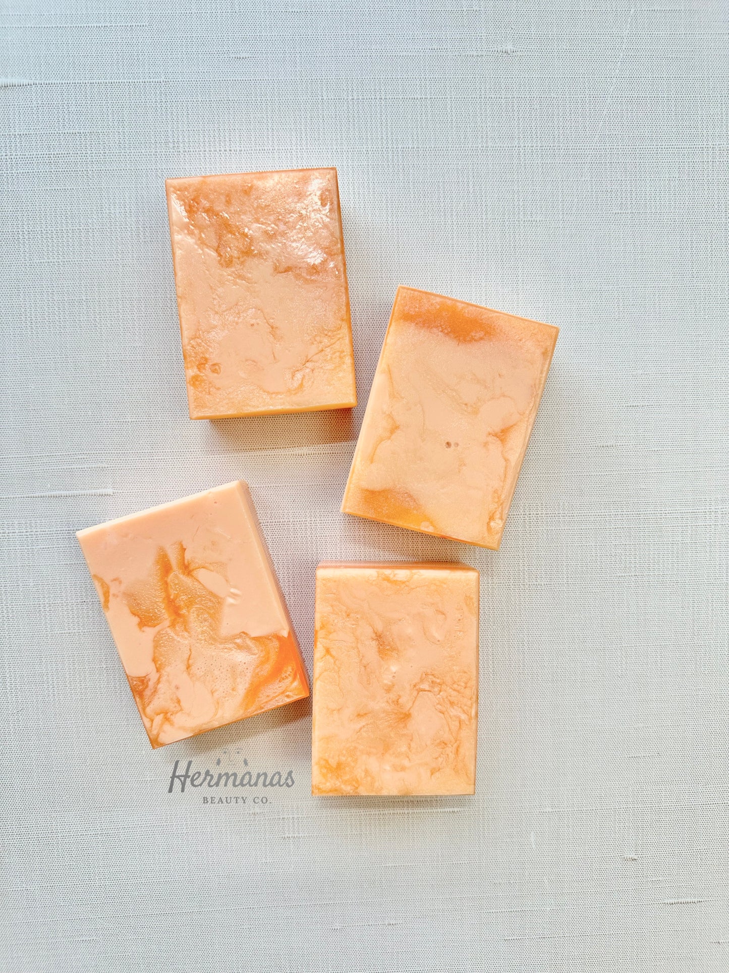 Four rectangular soap bars on a textured light gray background with 'Hermanas' branding.
