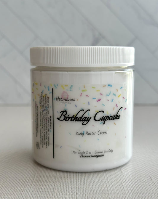 Jar of 'Birthday Cupcake' body butter cream with colorful sprinkles on a white background