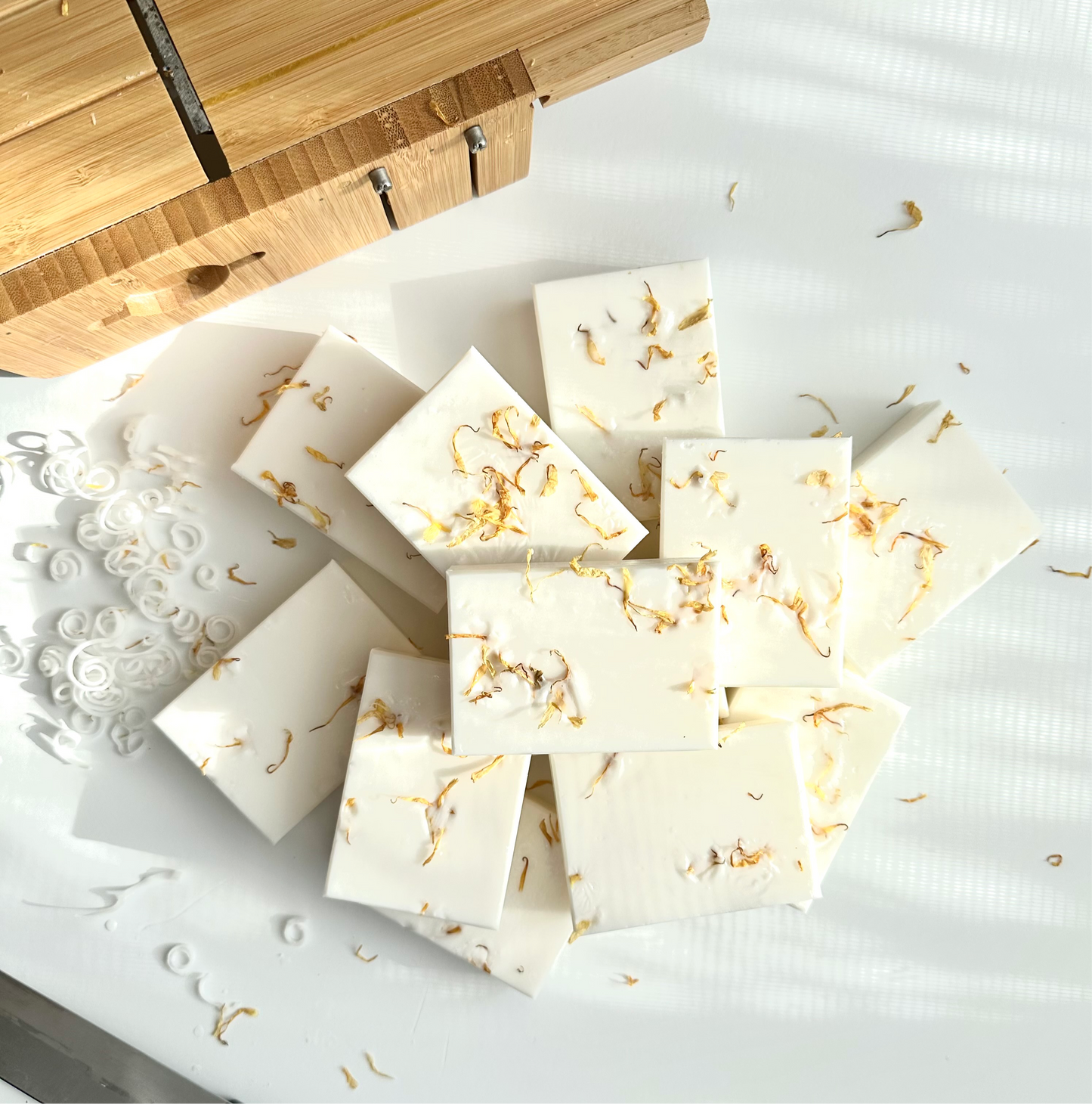 Coconut Milk Chamomile Soap Bar surrounded by chamomile flowers and yellow calendula petals