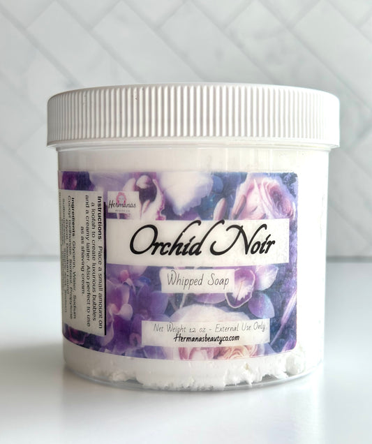 Clear whipped soap jar with a purple label with flowers on it.