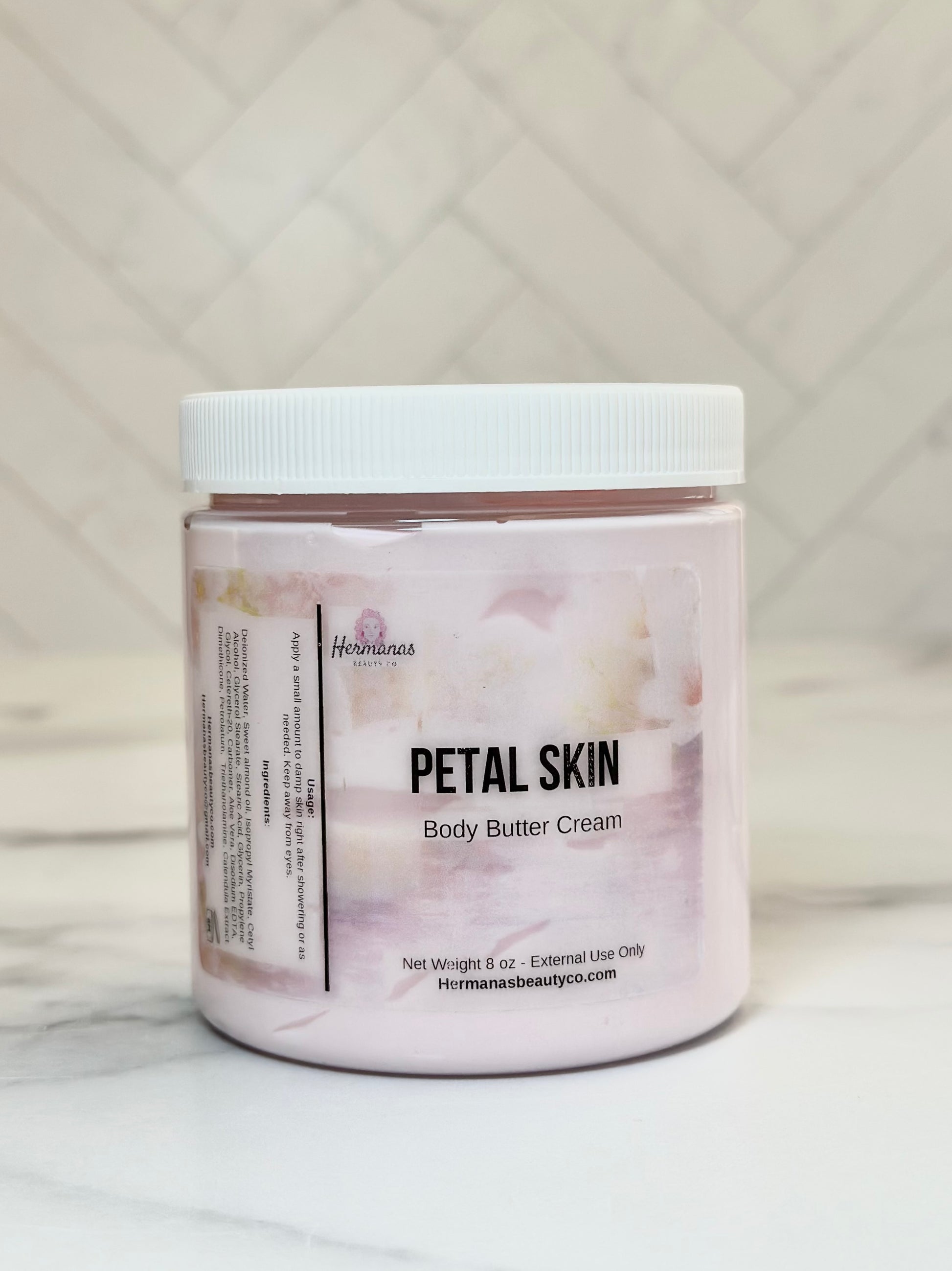 Jar of Petal Skin body butter cream on a marble surface with a neutral background