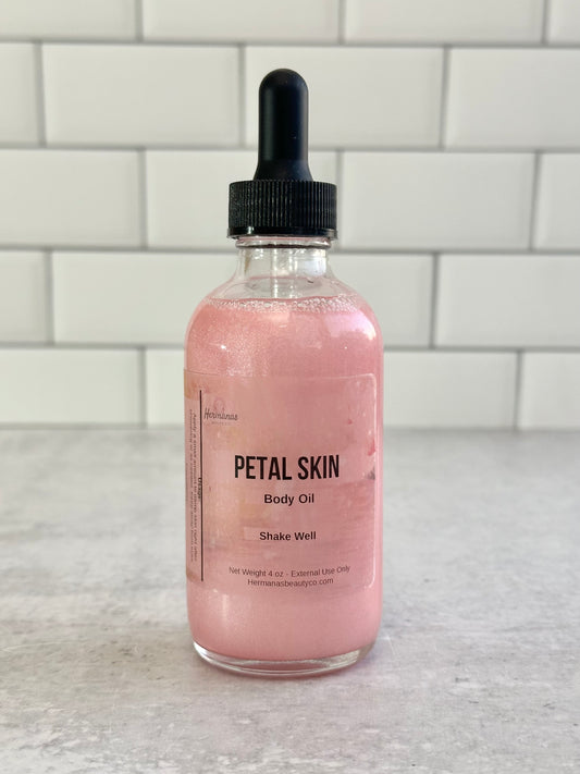Bottle of Petal Skin body oil on a marble surface with a tiled wall background