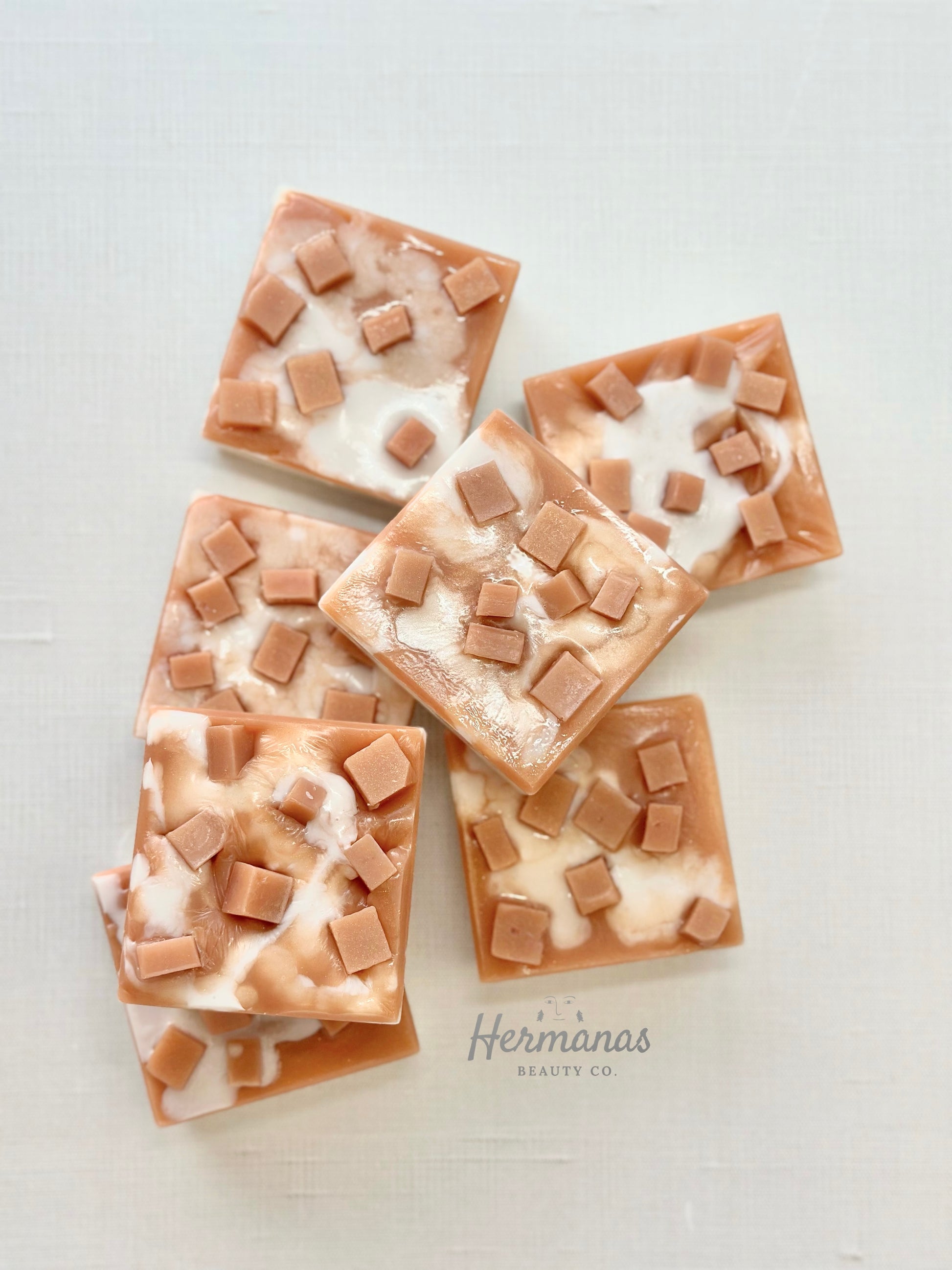 Five square soap bars with brown and white pattern on a light gray background, branded 'Hermiones Beauty Co'.