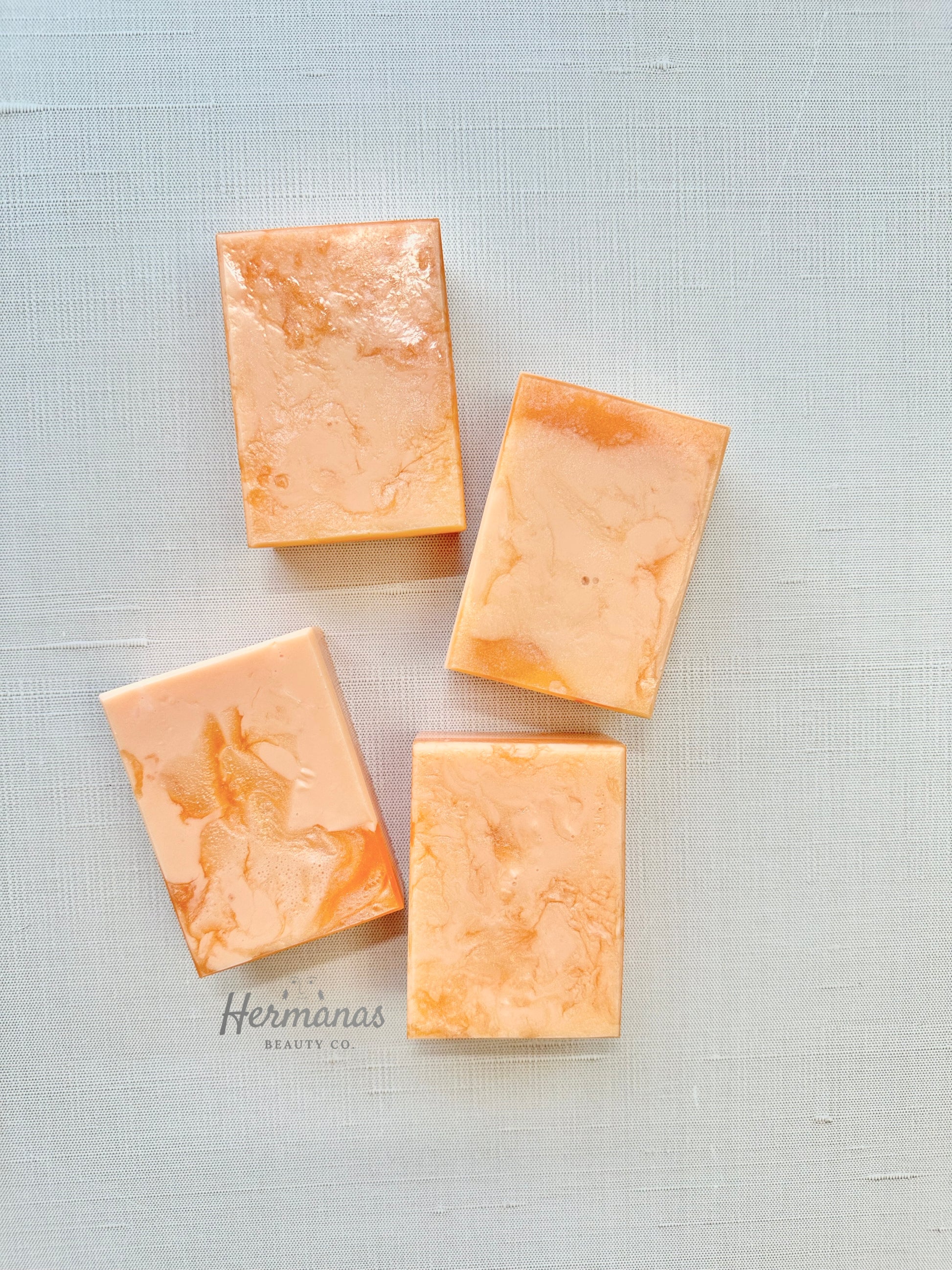 Four rectangular soap bars on a textured light gray background with 'Hermanas' branding.
