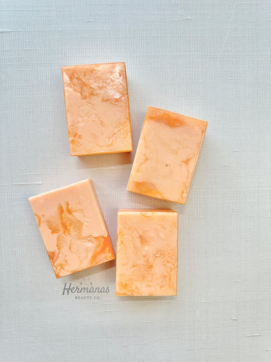 Four rectangular soap bars on a textured light gray background with 'Hermanas' branding.